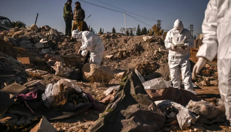 أعضاء من «الخوذ البيضاء» يعملون على توثيق مقبرة جماعية عثر عليها في دمشق (أ.ف.ب)